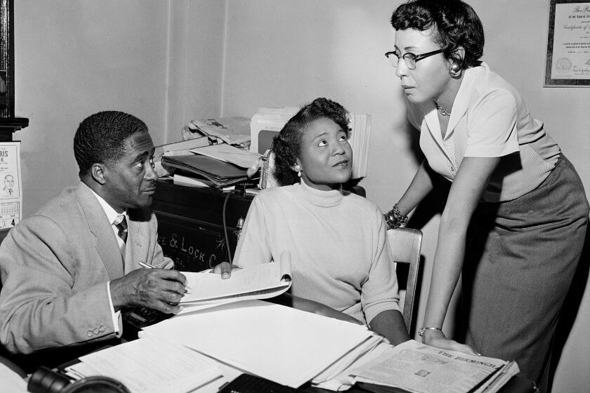 FILE - This file photo shows Autherine Lucy Foster, center, the first Black person to attend University of Alabama, discussing her return to campus following mob demonstrations in Birmingham, Ala., on Feb. 7, 1956. Angela Foster Dickerson, Foster's daughter, says her mother died Wednesday, March 2, 2022 and said a family statement would be released. (AP Photo/Gene Herrick, File)