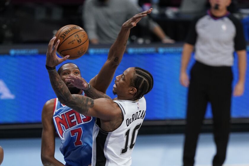 San Antonio Spurs' DeMar DeRozan, right, drives past Brooklyn Nets' Kevin Durant as James Harden, left, watches during the first half of an NBA basketball game Wednesday, May 12, 2021, in New York. (AP Photo/Frank Franklin II)