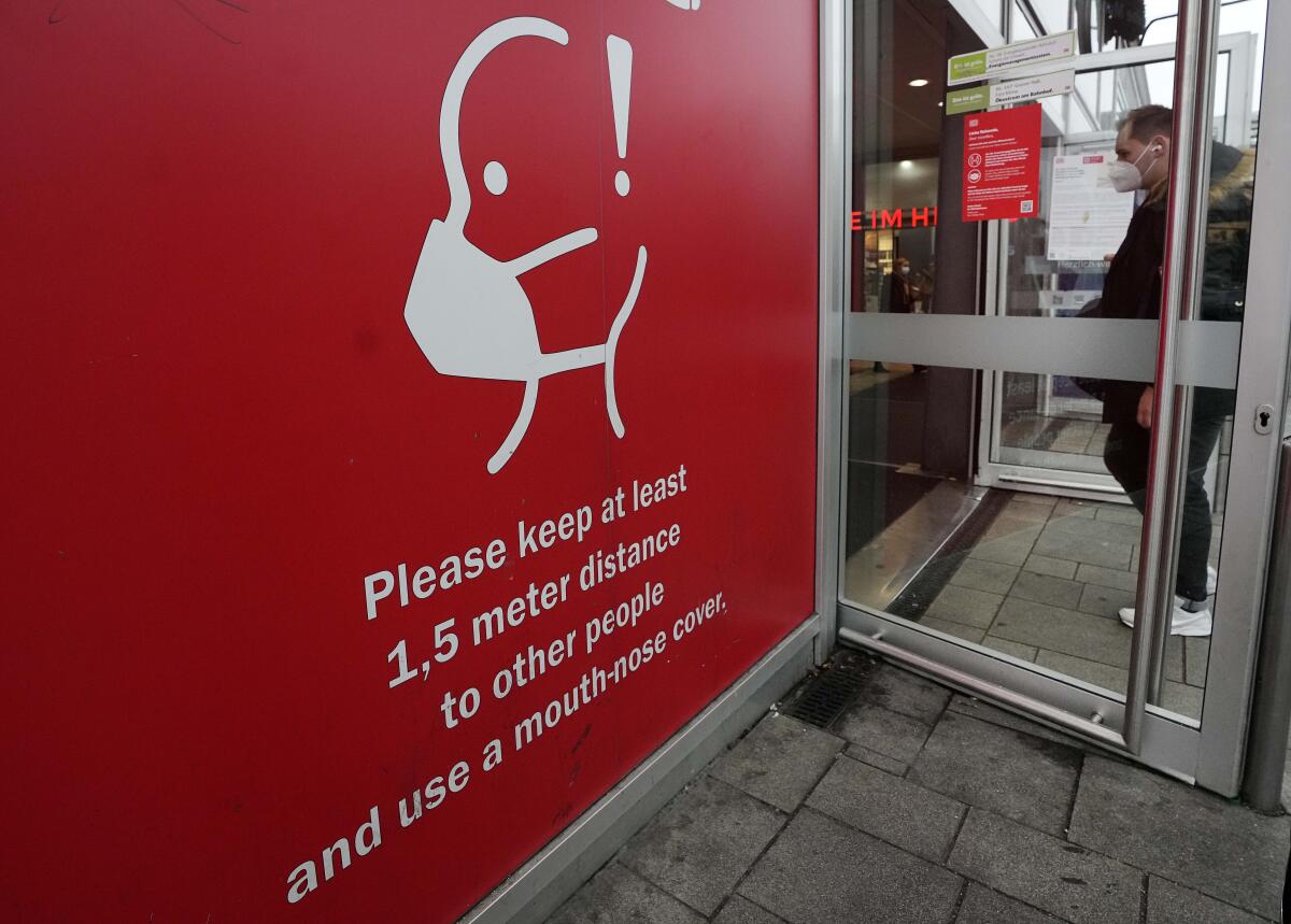 A sign at a German train station says "Please keep at least 1.5 meter distance to other people."