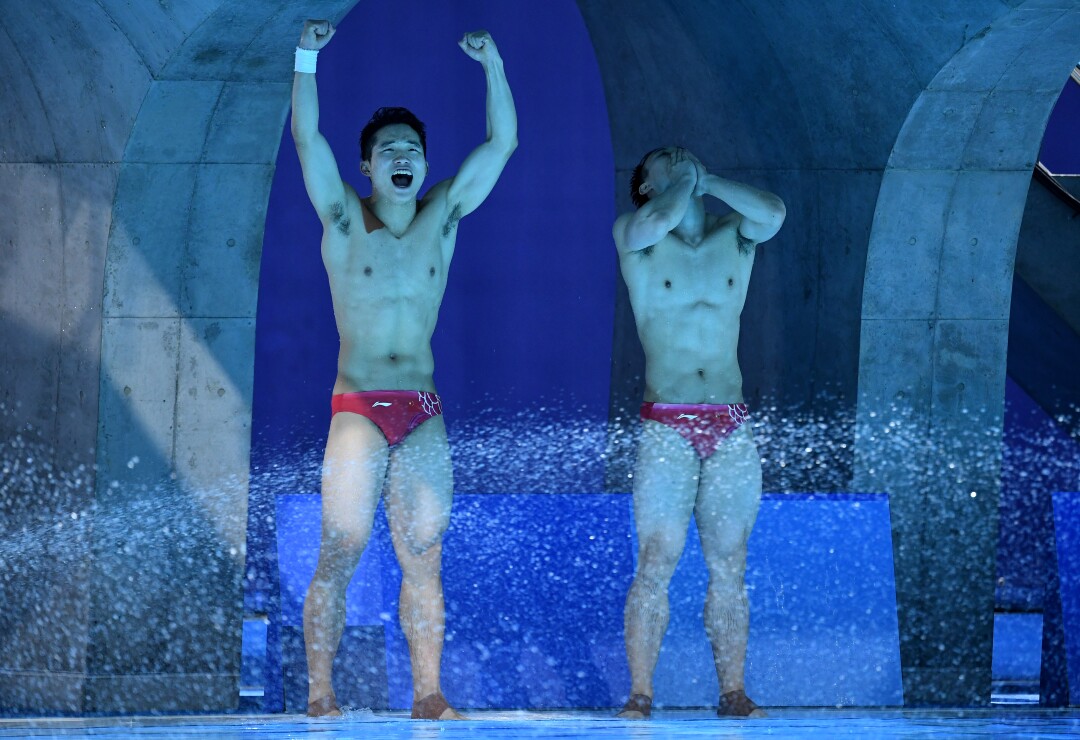 Two Chinese divers celebrate at poolside