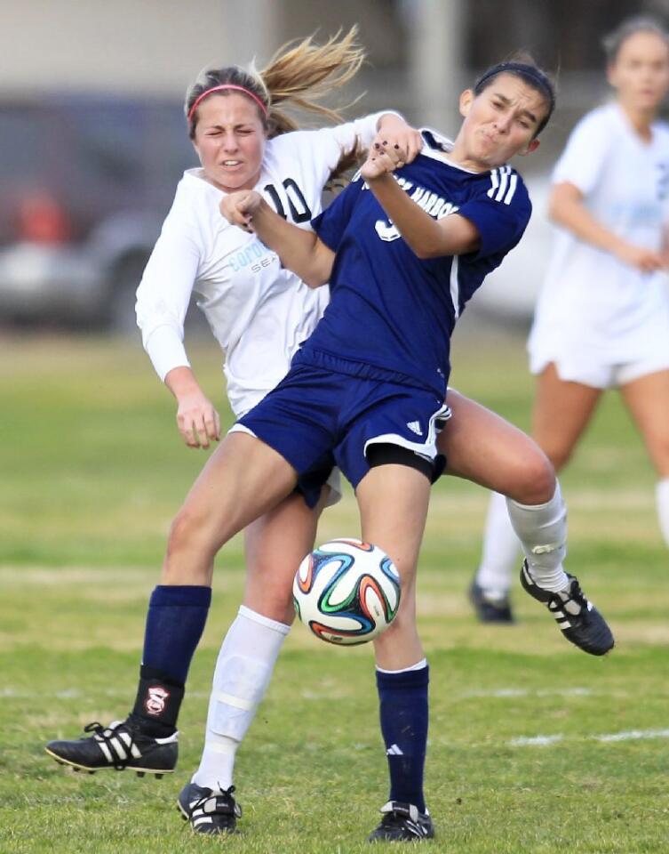 Corona del Mar High's Shelby Brown, left, battles Newport Harbor's Emily Gess, right, for a loose ball during the first half in the Battle of the Bay on Tuesday.