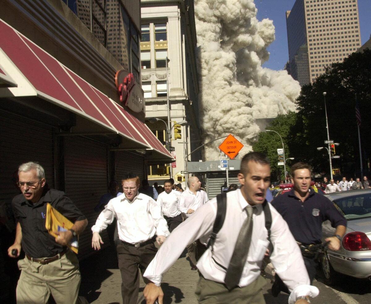 In this Sept. 11, 2001, file photo, people run from the collapse of one of the twin towers at the World Trade Center.