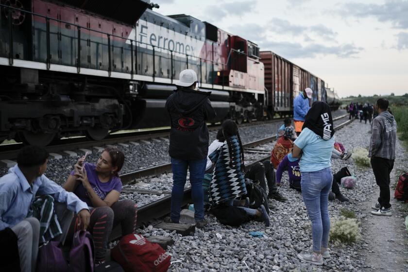 Migrantes observan un tren en marcha junto a las vías en las que esperan para subir a bordo de un vagón con el fin de dirigirse al norte de México, el 19 de septiembre de 2023, en Huehuetoca, México. (AP Foto/Eduardo Verdugo)