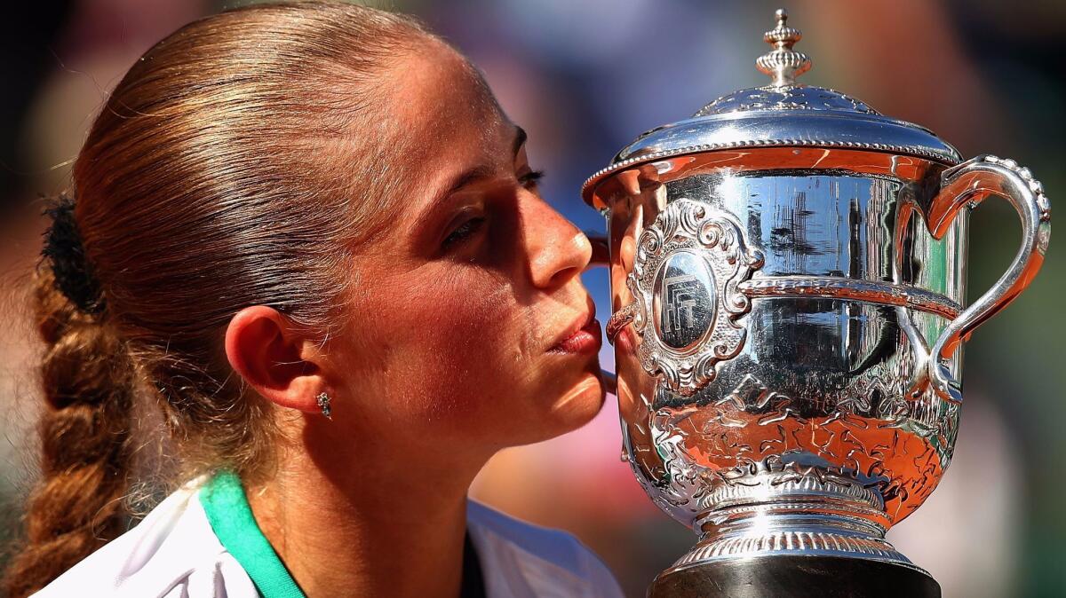 Jelena Ostapenko gives the winner's trophy a kiss after winning the women's title at the French Open on Saturday.