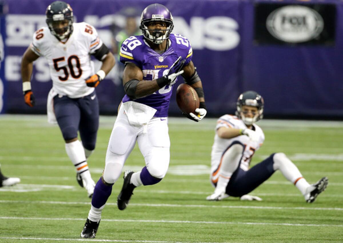 Vikings running back Adrian Peterson breaks into the clear past Bears defenders James Anderson (50) and Chris Conte on Sunday.