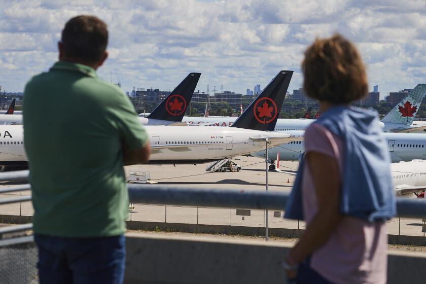 Viajeros observan los aviones de Air Canada en tierra debido a la huelga de sobrecargos de la aerolínea, en el Aeropuerto Internacional Pearson de Toronto, el 18 de agosto de 2025. (Sammy Kogan/The Canadian Press via AP)