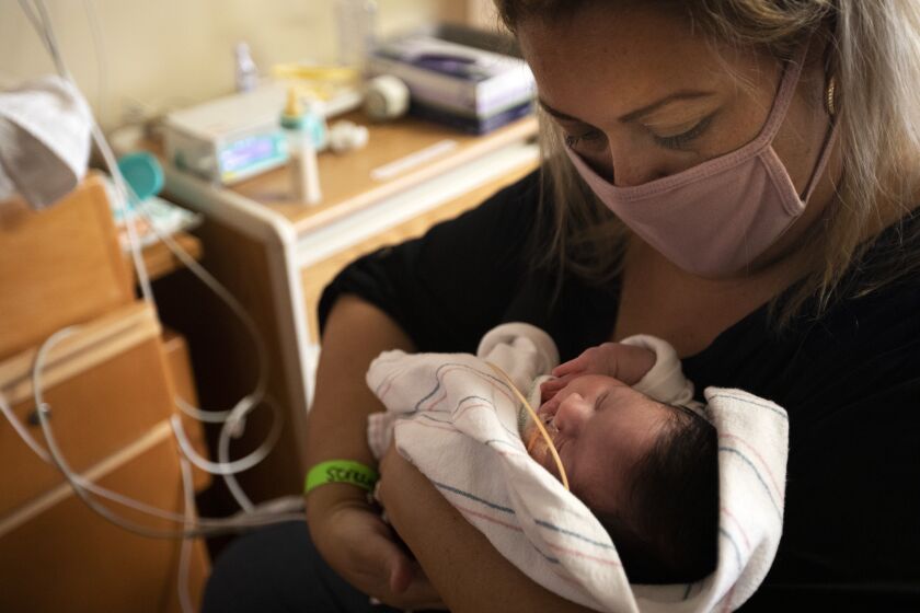 LOMA LINDA, CA - AUGUST 27: Monica Ramirez, 38, of Corona, feeds her new born Emiliana Ramirez inside the NICU at LomaLindaUniversityChildren's Hospital on Thursday, Aug. 27, 2020 in Loma Linda, CA. Monica was pregnant and became Covid positive. She gave birth to her daughter while in a coma at LomaLindaUniversityChildren's Hospital during the global coronavirus pandemic. (Francine Orr / Los Angeles Times)