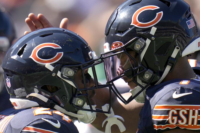 Chicago Bears quarterback Justin Fields, right, congratulates running back Khalil Herbert after Fields' touchdown pass to Herbert during the second half of an NFL football game against the Denver Broncos Sunday, Oct. 1, 2023, in Chicago. (AP Photo/Erin Hooley)