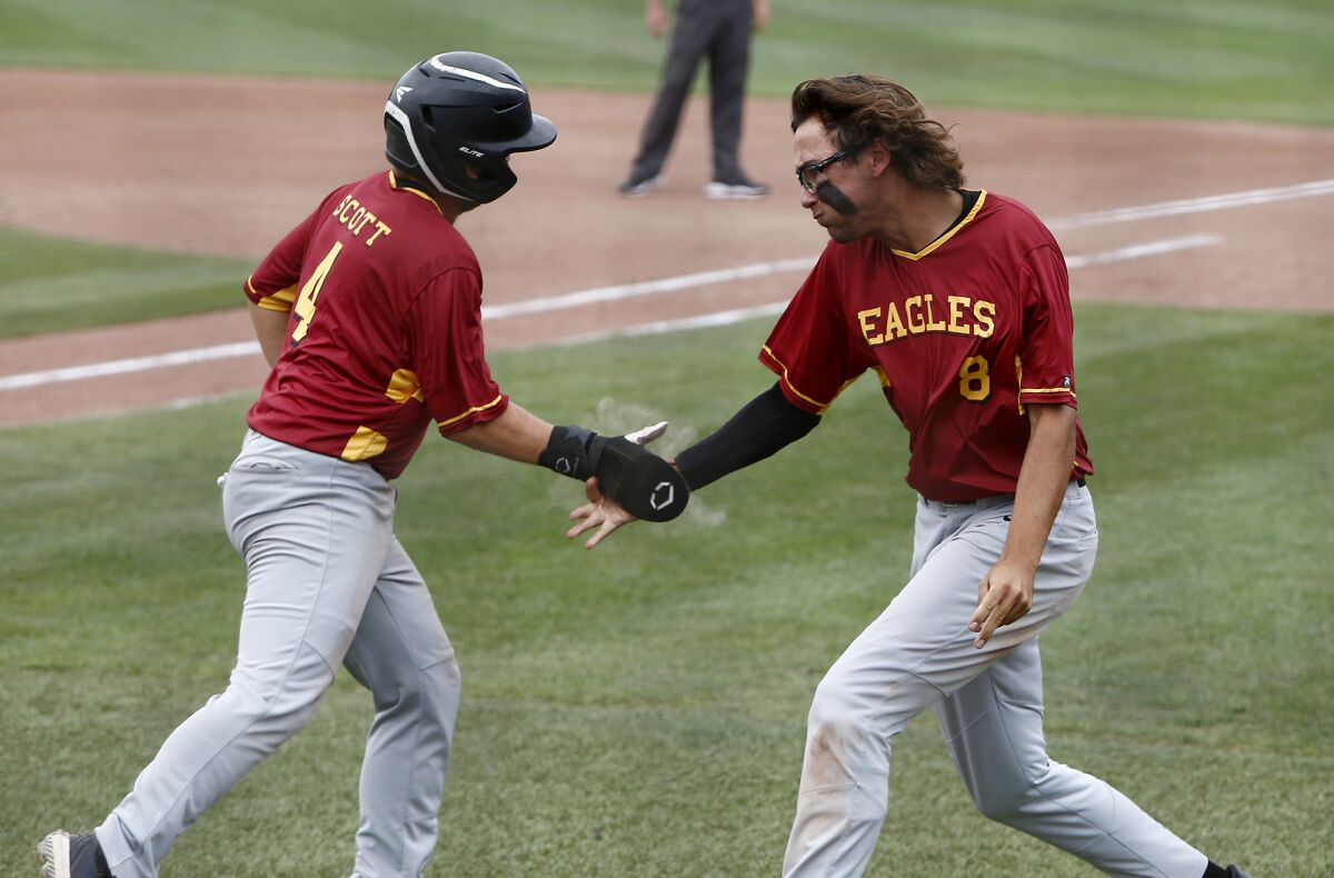 Estancia's Jack Moyer, right, congratulates teammate Trevor Scott after he scored the go-ahead run in Saturday's game.