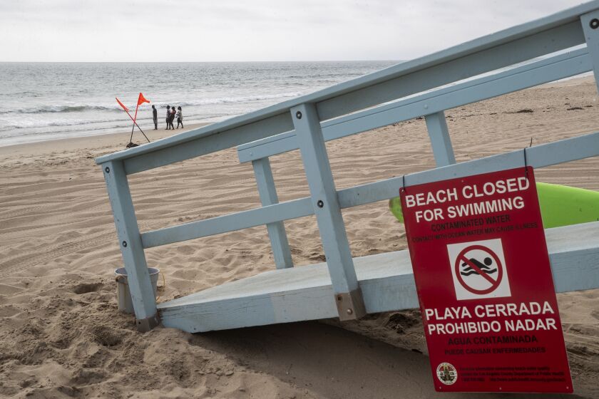 PLAYA DEL REY , CA - JULY 12, 2021: A sign at a lifeguard station at Dockweiler State Beach in Playa del Rey warns the public that the beach is closed to swimming as a result of 17 million gallons of untreated sewage, caused by a power outage at the nearby Hyperion Treatment Plant in Playa Del Rey, spilling into the ocean. (Mel Melcon / Los Angeles Times)
