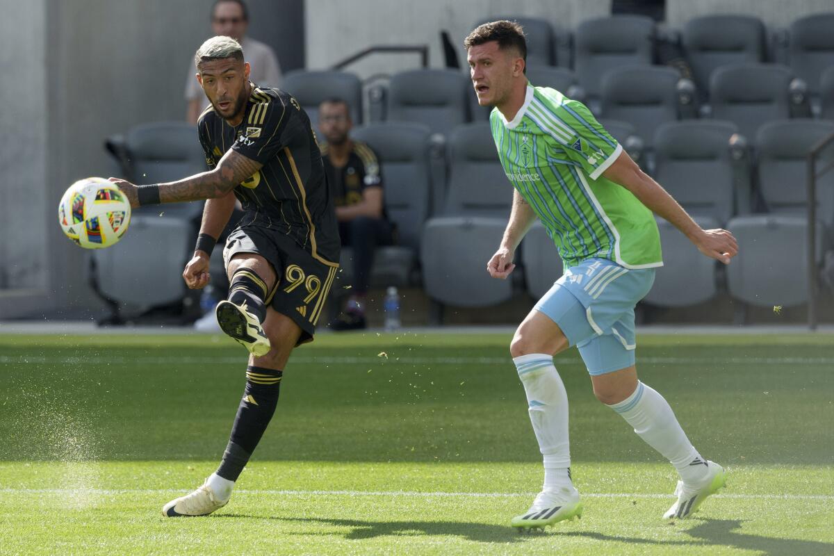 LAFC forward Denis Bouanga kicks the ball in front of Seattle Sounders defender Nathan.