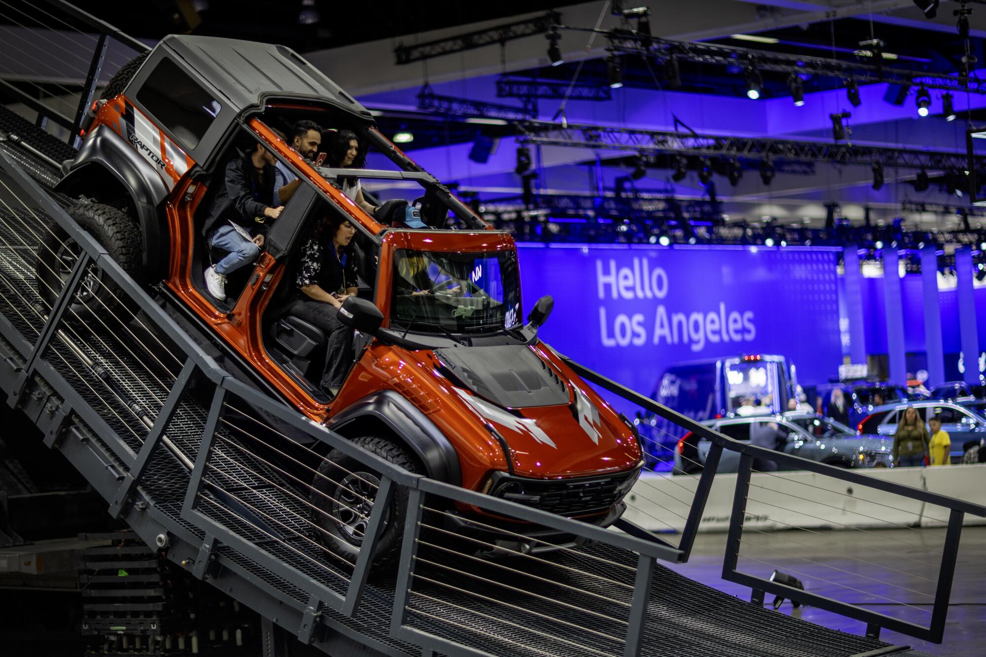 People take a test drive in a Ford Bronco Raptor on Bronco Mountain at the L.A. Auto Show.