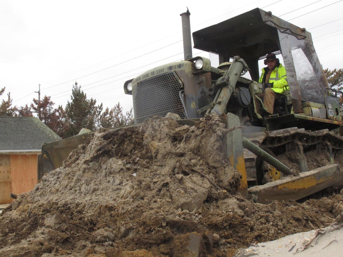 The federal government spent about $150 billion on relief efforts after Hurricane Katrina, and has so far committed about $60 billion for Superstorm Sandy. Above: A public works employee uses a bulldozer to rebuild a sand dune in Mantoloking N.J. that was washed away by a lingering winter storm that caused flooding and other damage at the Jersey shore, parts of which are still struggling to recover from Superstorm Sandy.