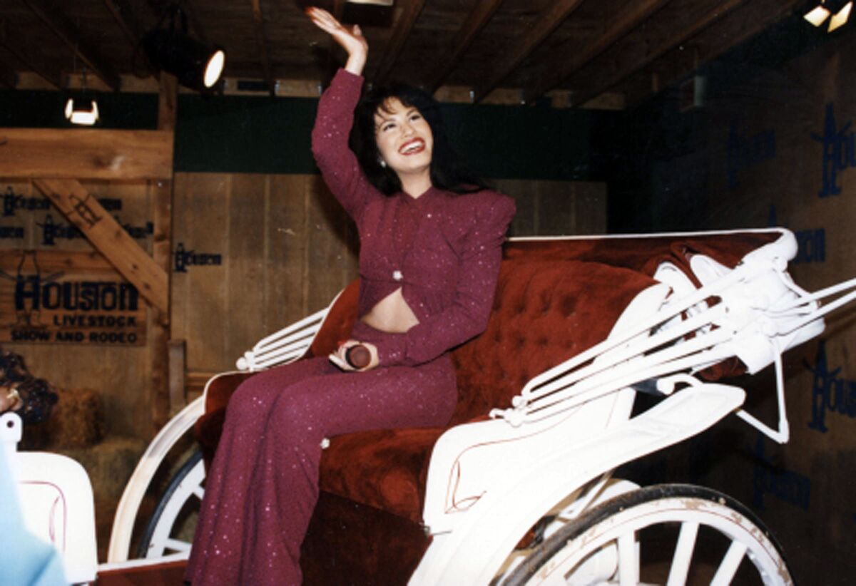 A woman waves from a carriage.