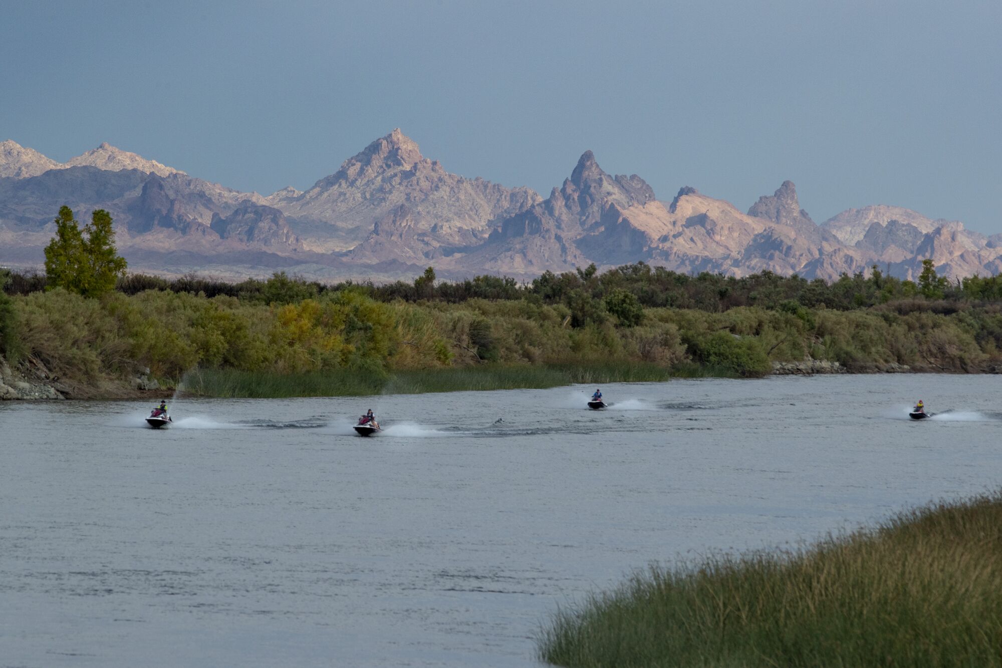 Jet skiers power up the Colorado River against a backdrop of The Needles