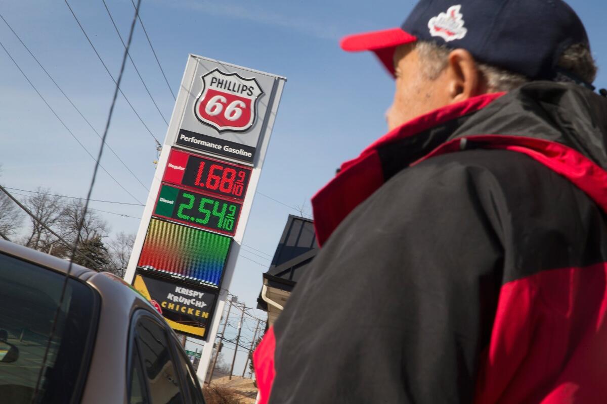 Motorist Lou Brazils fills his tank at a gas station Tuesday in Dellwood, Mo. The average price of a gallon of gas in the United States is projected to dip below $2 this week, according to a new report from GasBuddy.com, which tracks gas prices.