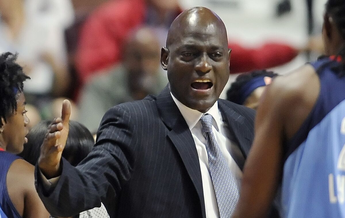 Coach Michael Cooper greets a player along the sideline while coaching the Atlanta Dream in 2016.