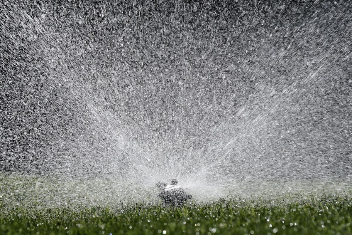 Water flies from a sprinkler watering a lawn, in Sacramento, Calif., Tuesday, May 10, 2022. California's water usage jumped nearly 19% in March during one of the driest months on record, state officials announced, Tuesday, May 10, 2022. (AP Photo/Rich Pedroncelli)