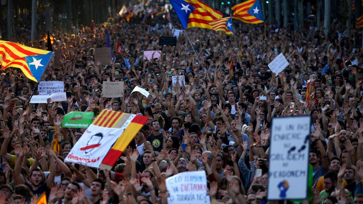 Demonstrators shake their hands as a sign of peaceful protest as they march in downtown Barcelona, Spain, on Oct. 3, 2017.