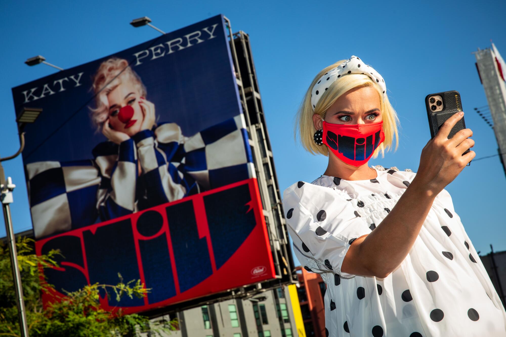 Pregnant pop star Katy Perry takes a selfie with a billboard promoting her new album, “Smile."