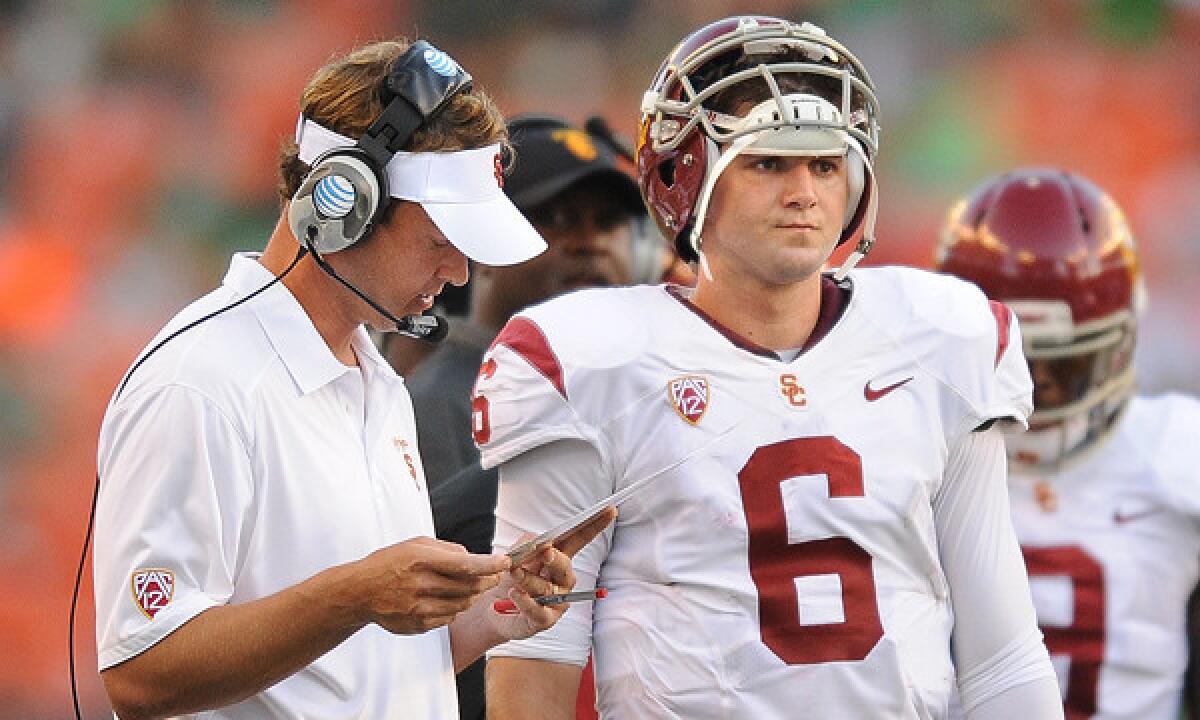 Lane Kiffin goes over plays with quarterback Cody Kessler in the season opener at Hawaii.