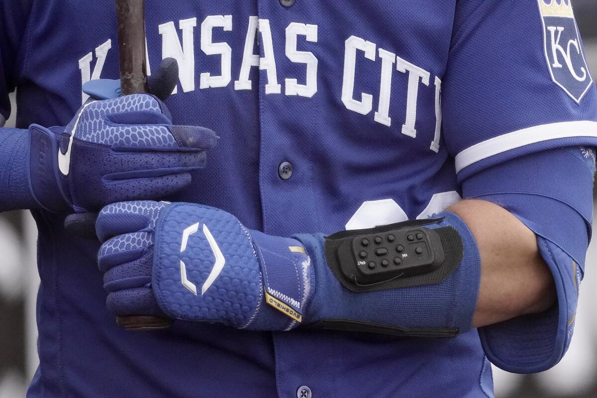 Kansas City Royals catcher Cam Gallagher wears a wrist-worn device used to call pitches as he prepares to bat.