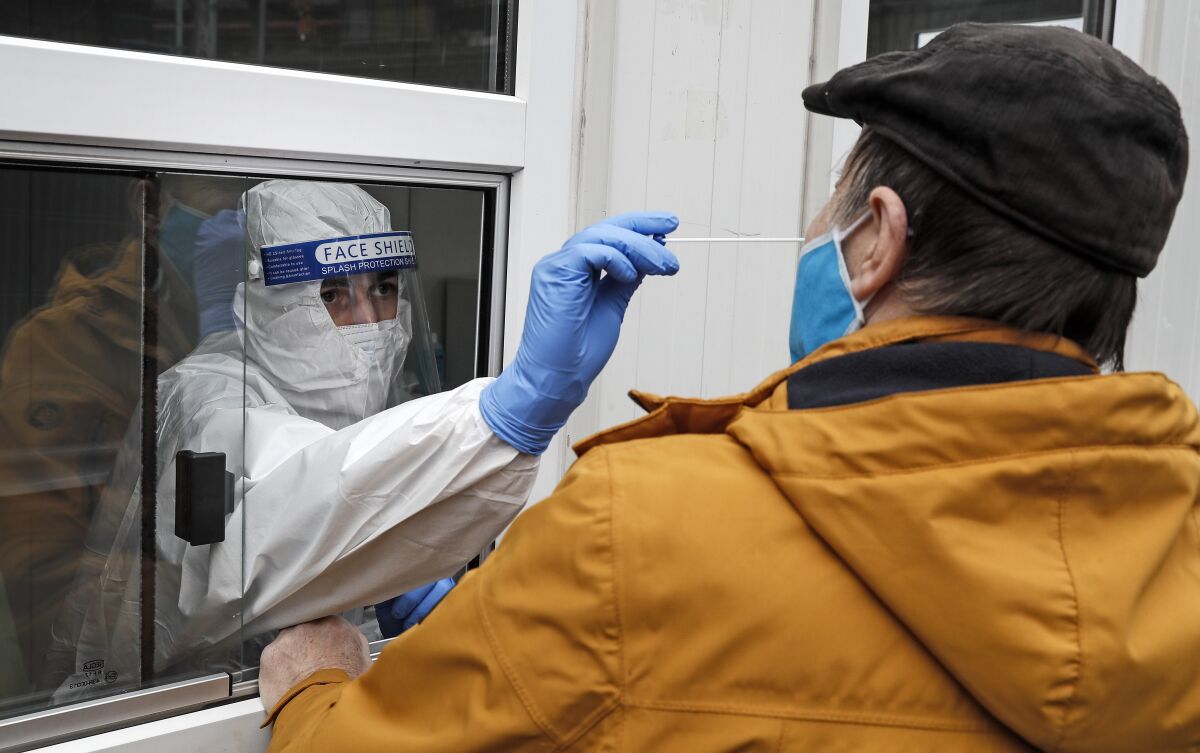 Medical staff tests a man at a coronavirus test center in Cologne, Germany, on Thursday. 