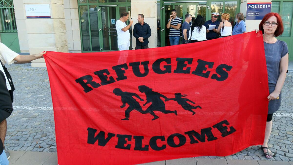 Migrant supporters hold a banner in front of the police station in Eisenstadt, Austria, on Thursday.