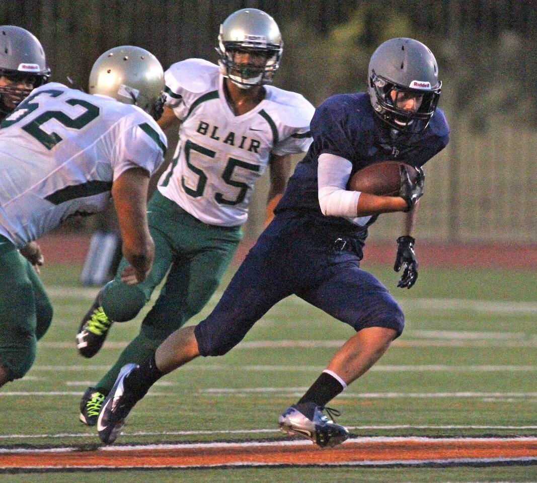 Flintridge Prep's Elliot Witter turns upfield for a gain up the middle against Blair in the first half of a non-league football game at Occidental College in Eagle Rock on Friday, August 29, 2014.