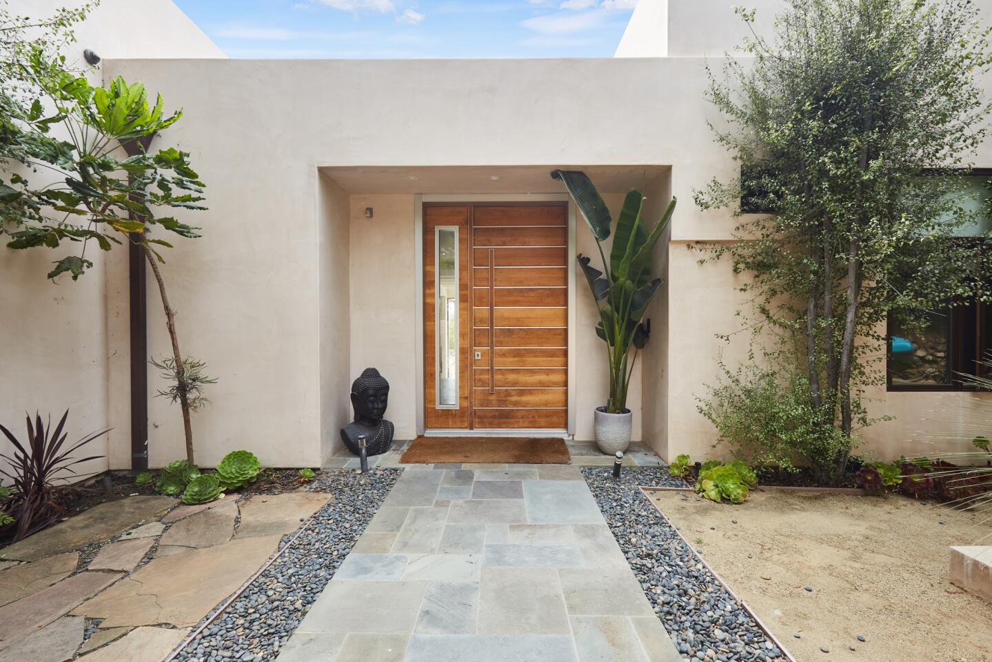 Stone pavers lead to the front door in a modular, modern exterior.