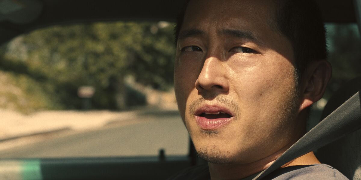 Steven Yeun looks out his car window in a scene from "Beef."
