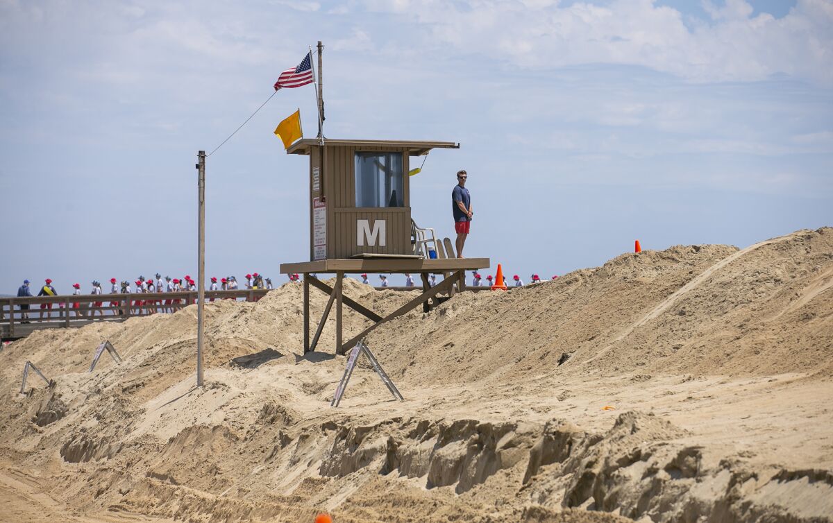 Brandon LaGrotta, a Newport Beach lifeguard, stands watch at a tower.