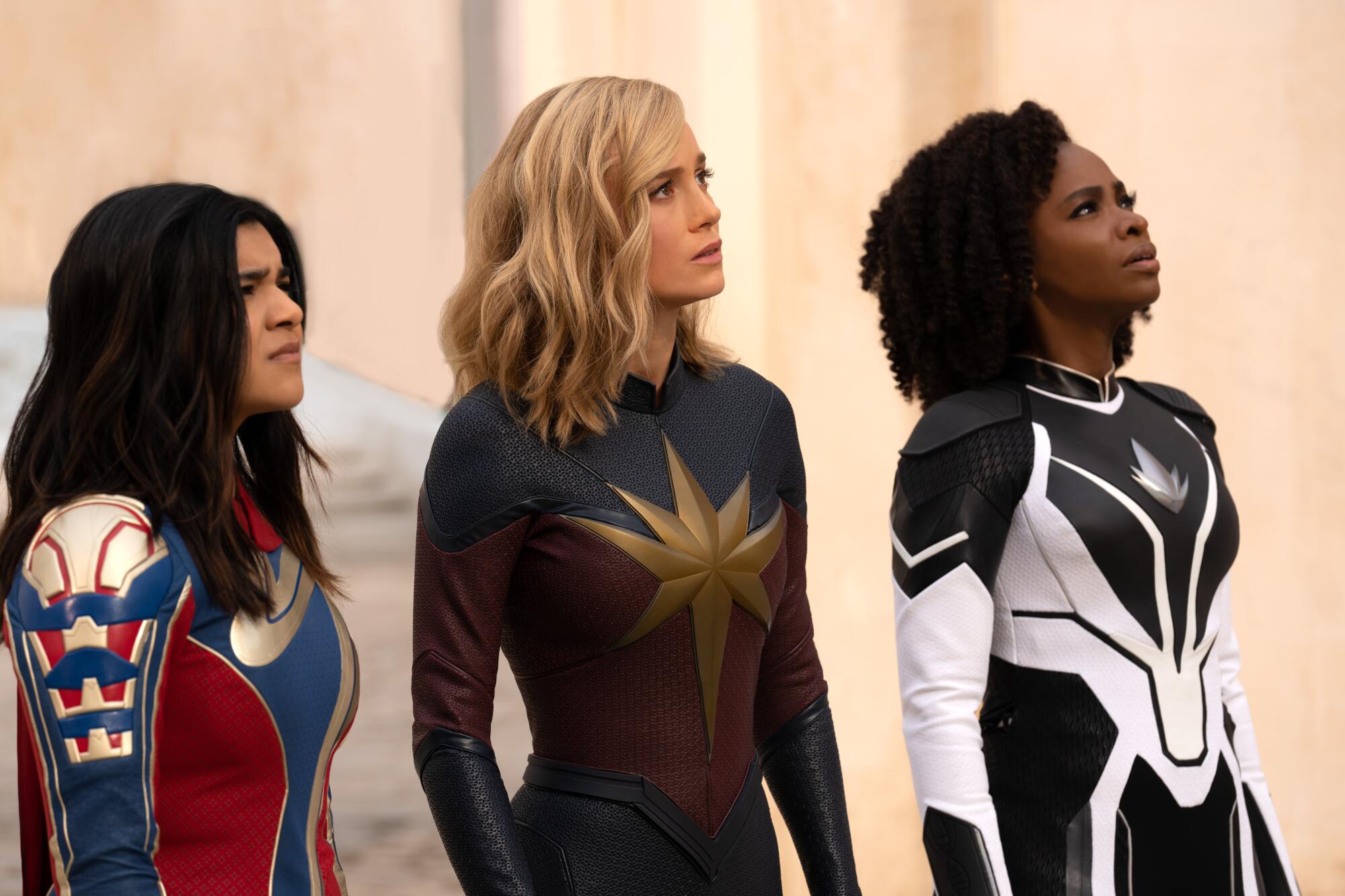 Three female superheroes look up.