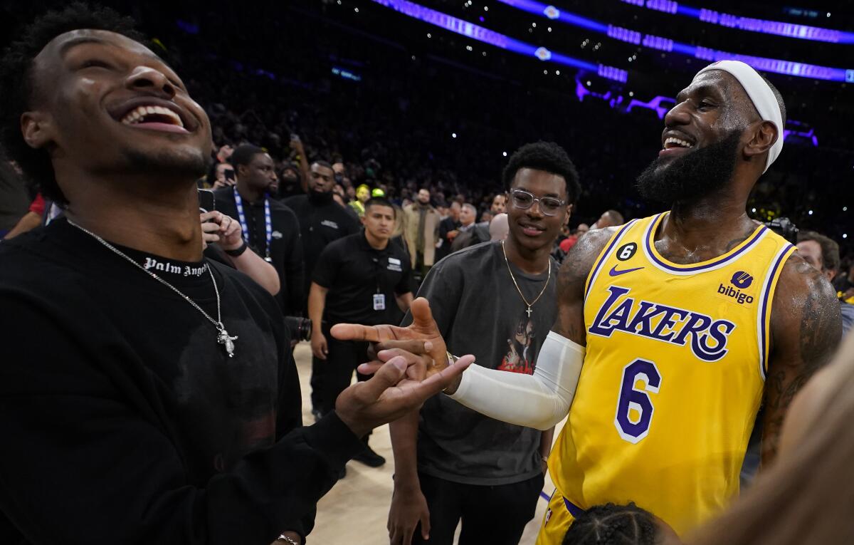 Lakers forward LeBron James, right, celebrates with his sons Bronny, left, and Bryce 