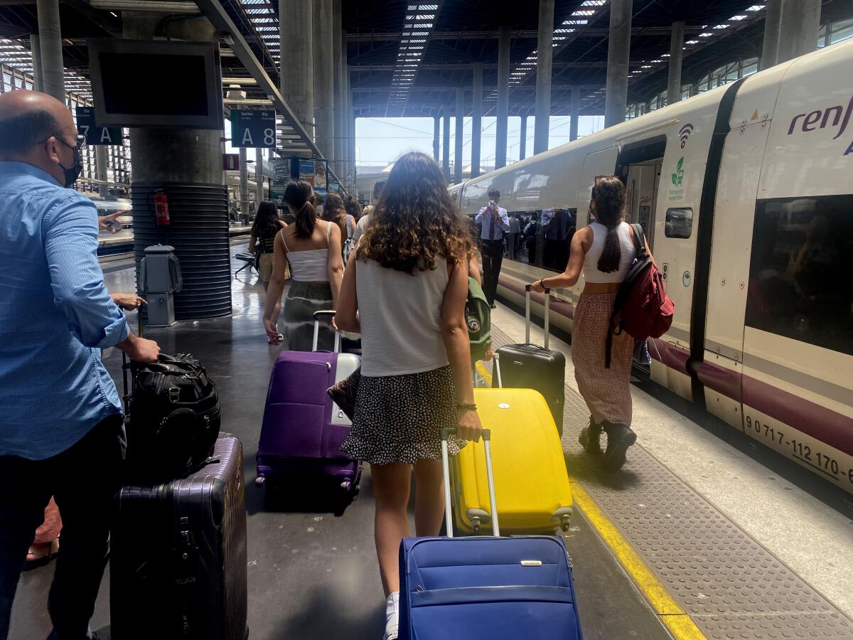 Tourists arrive at a train station in Malaga, Spain.