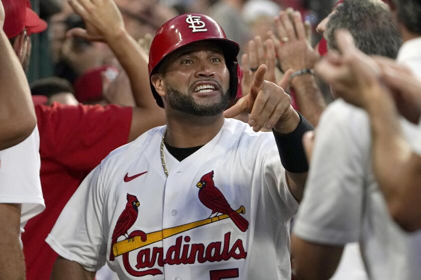 St. Louis Cardinals' Albert Pujols (5) is congratulated by teammates after scoring on a two-run home run.