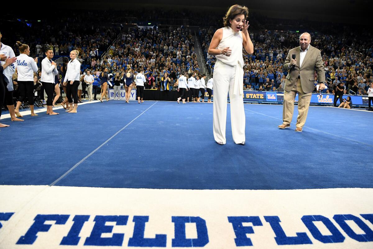UCLA head gymnastics coach Valorie Kondos Field reacts as athletic director Dan Guerrero presents her with the naming of the floor during a retirement ceremony at Pauley Pavilion.