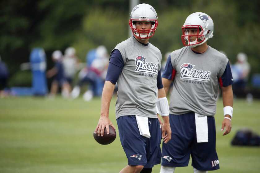 New England Patriots quarterbacks Tom Brady, left, and Jimmy Garoppolo stand together on the field during an NFL football organized team activity in Foxborough, Mass., Thursday, June 12, 2014. (AP Photo/Michael Dwyer)