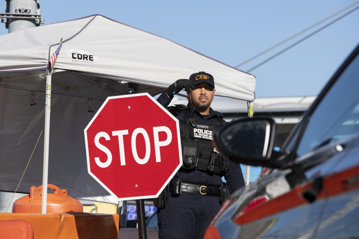 A U.S. Customs and Border Protection officer asks drivers to show documentation