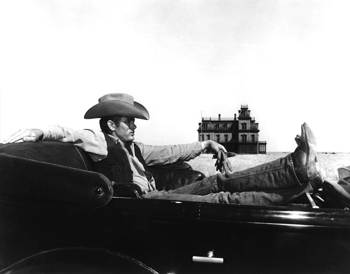A man in a cowboy hat and boots in the 1956 movie "Giant," directed by George Stevens.