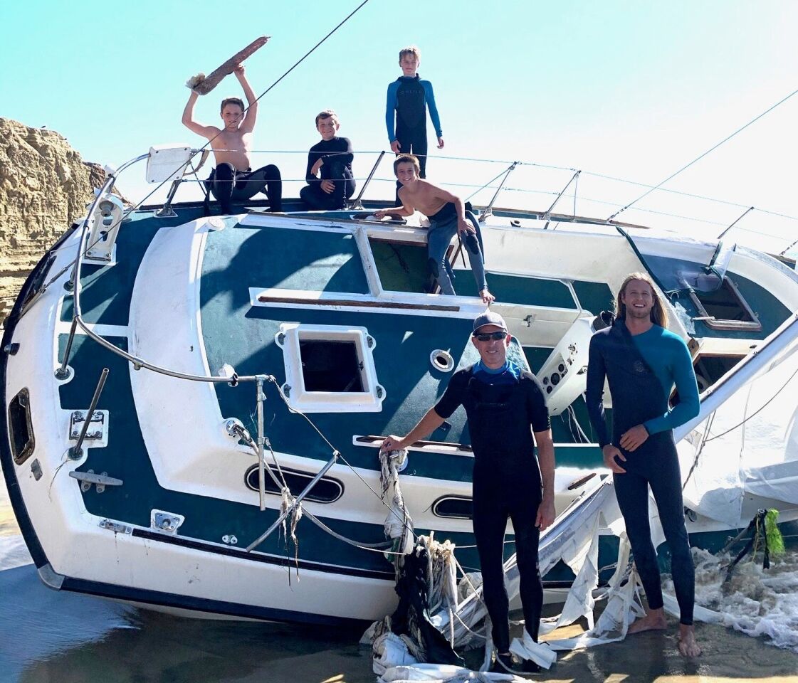 From left, Bohdi Gray, Trent Bruskotter, Colin Rahilly, Wyatt Smith, Paul Rahilly and Hunter Mitchell check out a boat that went aground recently at Point Loma surf spot Subs.