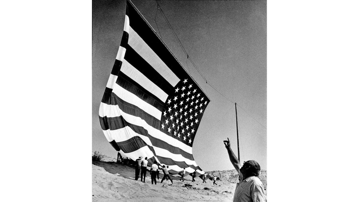 June 25, 1976: Rancher Bob Older signals winch operator while his 102 ft. x 67 ft. American Flag is unfurled for test before offical ceremony on July 4, 1976. This photo was published in the June 28, 1976 Los Angeles Times.