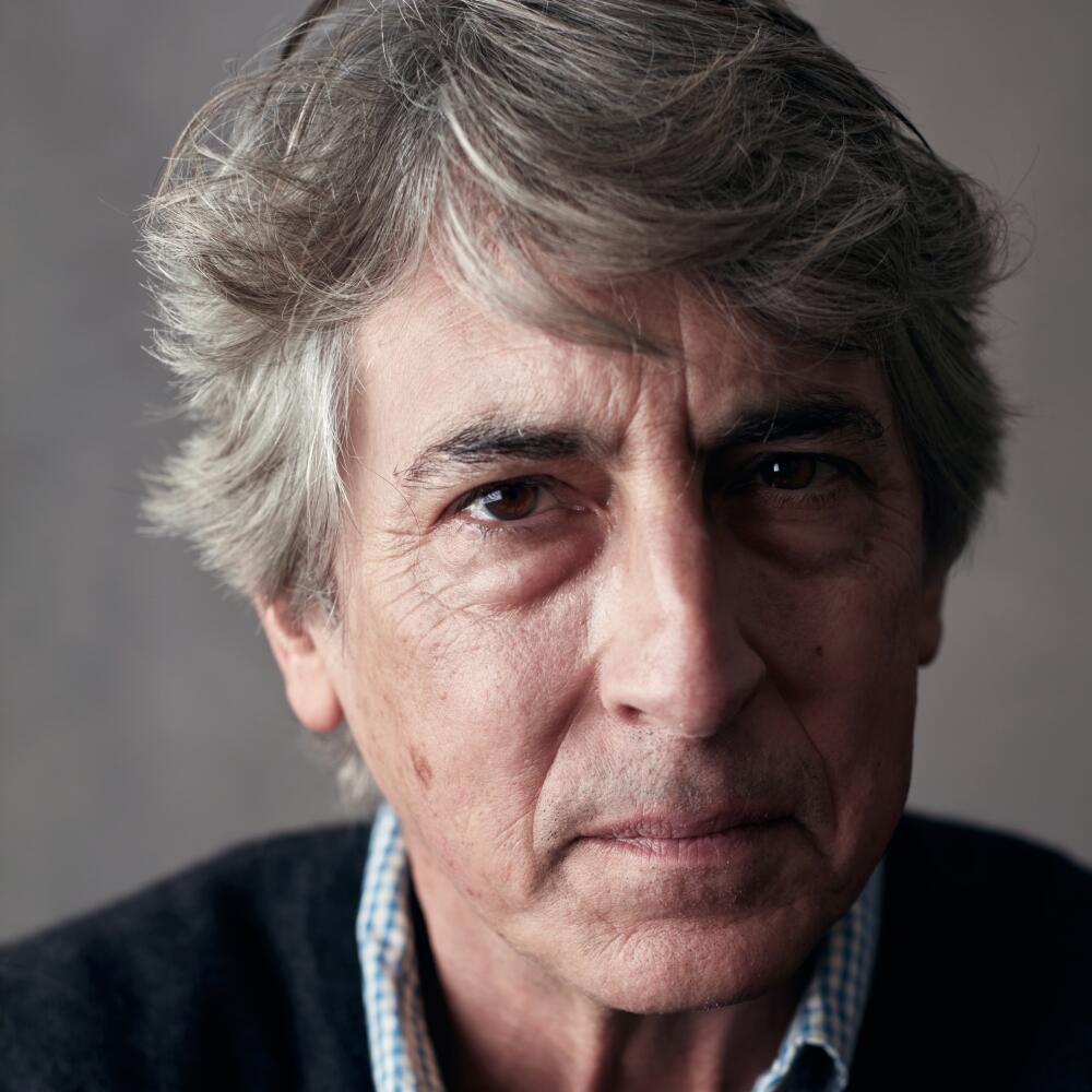A man with wavy gray hair poses for a photo.