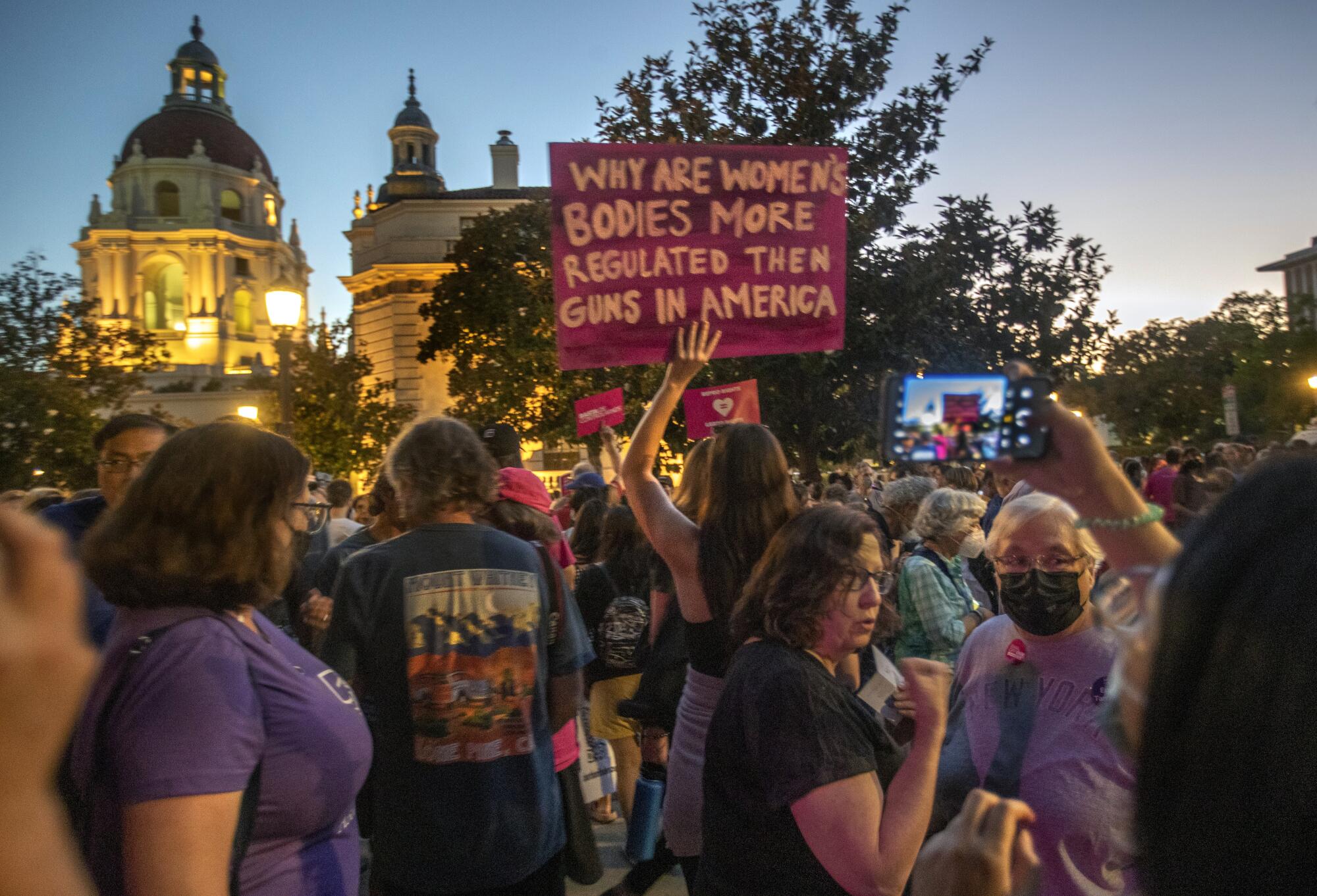 Protesters gather outdoors at twilight