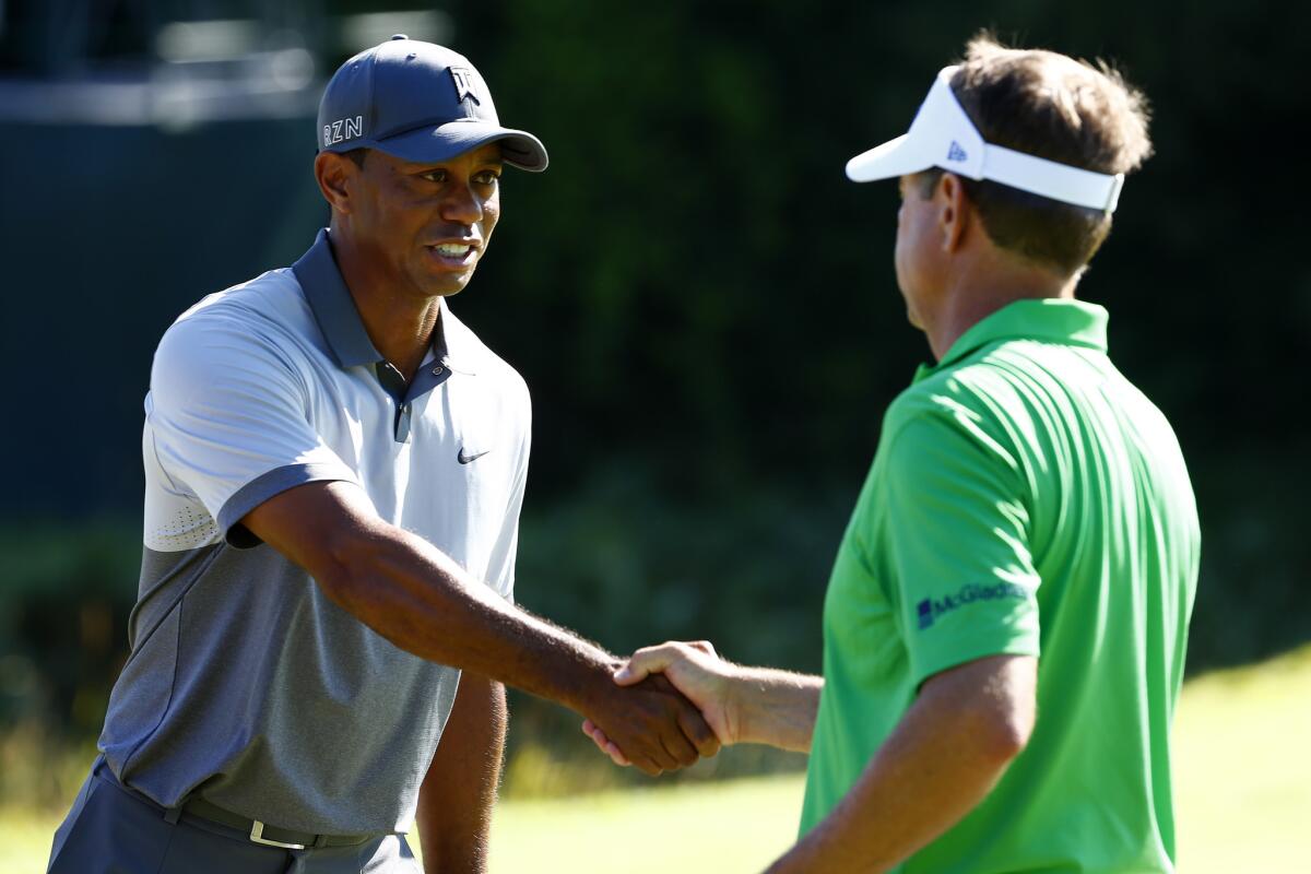 Tiger Woods and Davis Love III shake hand after playing a practice round Tuesday at Whistling Straits in preparation for the PGA Championship.