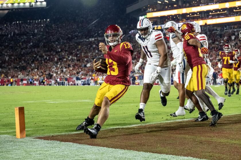 USC quarterback Caleb Williams points toward the crowd as he runs into the the end zone