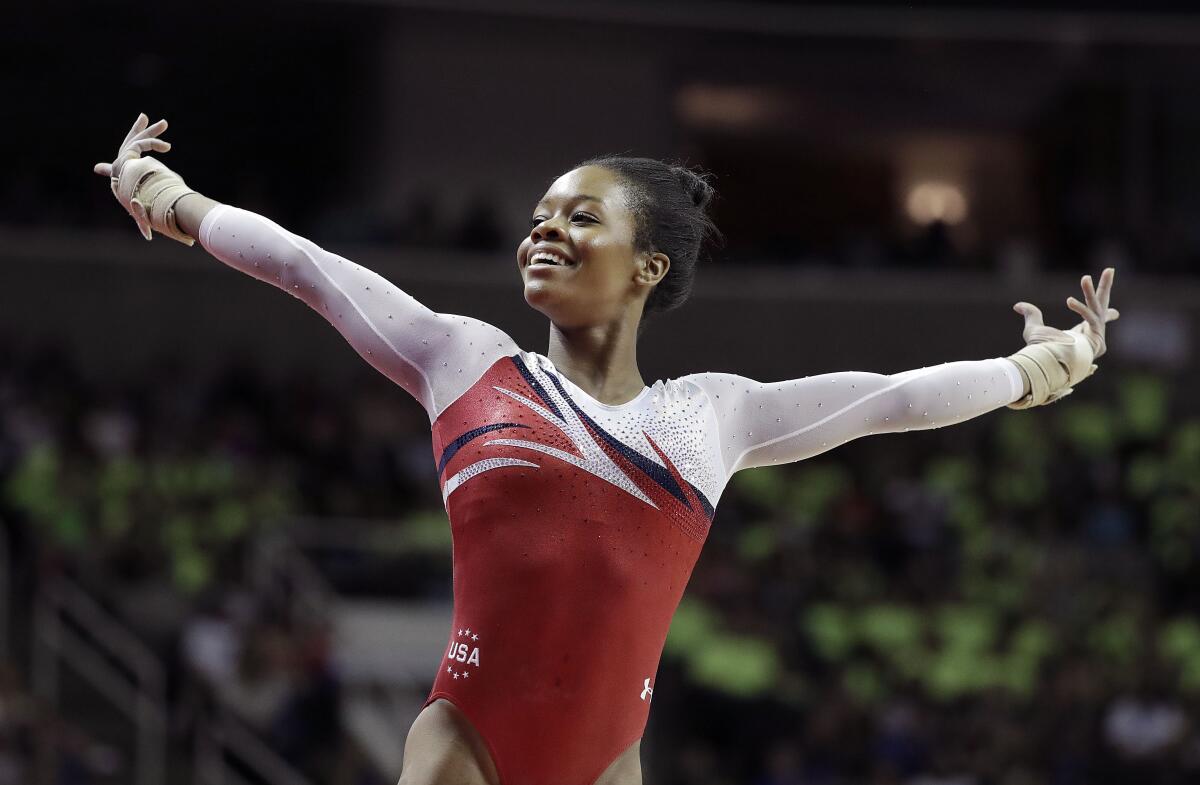 Gabby Douglas smiles after competing on the floor exercise during the 2016 U.S. Olympic gymnastics trials.