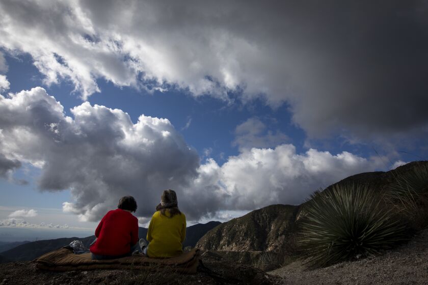 SAN GABRIEL MOUNTAINS, CALIF. - DECEMBER 24: Michelle Young, left, and Heather Kohos, right, sits and enjoy the view just off the off Angeles Crest HWY in the San Gabriel Mountains, Calif. on Tuesday, Dec. 24, 2019. Two cold Pacific storm systems will bring rain and snow to Southern California for most of the week. The second front arrives on Christmas and will last through most of Thursday. (Francine Orr / Los Angeles Times)