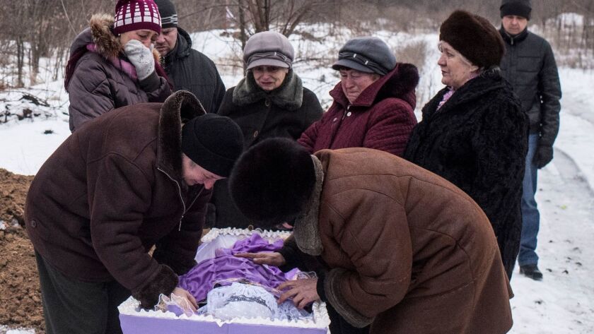 Relatives of Elena Volkova, who was killed during shelling, grieve at her funeral in Avdiivka, eastern Ukraine. Fighting between government forces and Russian-backed separatist rebels has escalated.