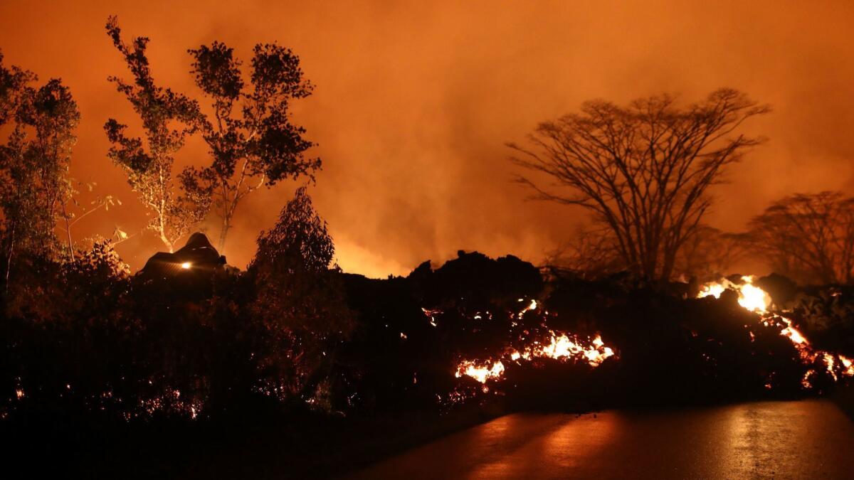 Lava from a Kilauea volcano fissure advances on a roadway in Leilani Estates, on Hawaii's Big Island, on Friday. Such images aren't helping the tourism industry.